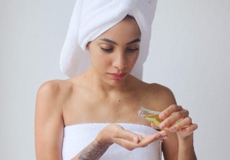 Uma menina usa óleo para rejuvenescer a pele