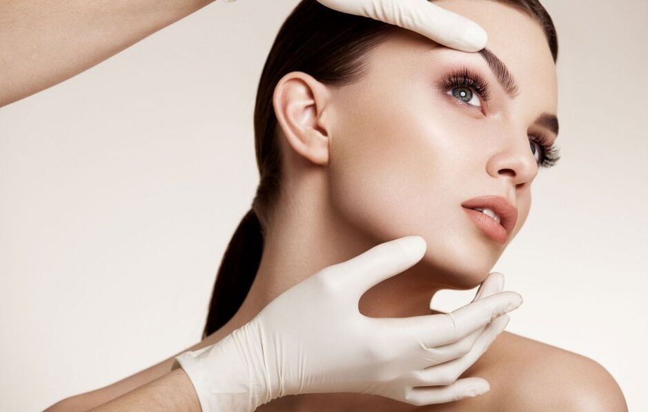 cosmetologista examina a pele do rosto antes do rejuvenescimento
